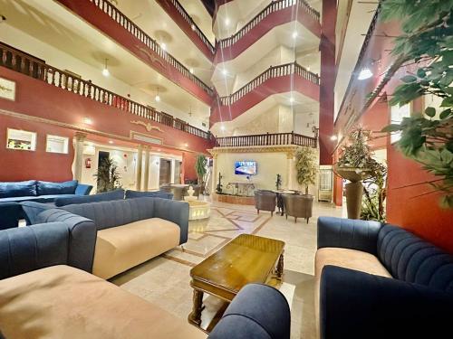 a large living room with blue couches and a tv at Celine Furnished Apartments in Jeddah