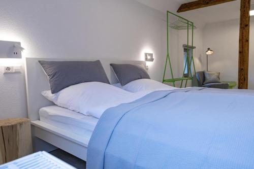 a bedroom with a blue and white bed and a chair at Landurlaub mit neugierigen Blicken in den Pferdestall, eingezäuntem Garten, Kamin und Sauna in Rot am See