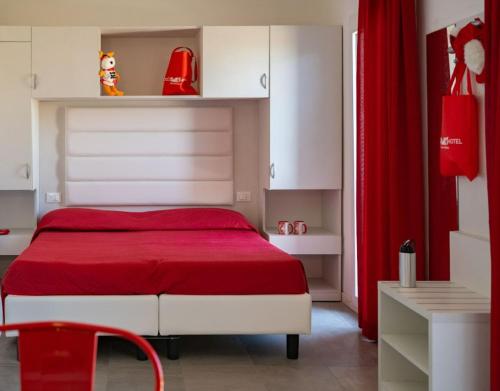a bedroom with a red bed with a red blanket at Ciccio Hotel in Misano Adriatico