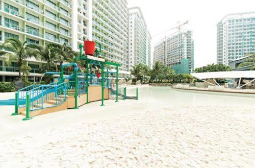 einen Spielplatz mitten in einer Stadt mit hohen Gebäuden in der Unterkunft Azure Urban Resort Condo Parañaque near NAIA Airport Free Highspeed WIFI and Netflix in Manila