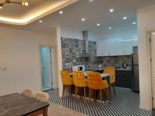 a kitchen with a table and some yellow chairs at Zemilo Hotel Apartment in Addis Ababa