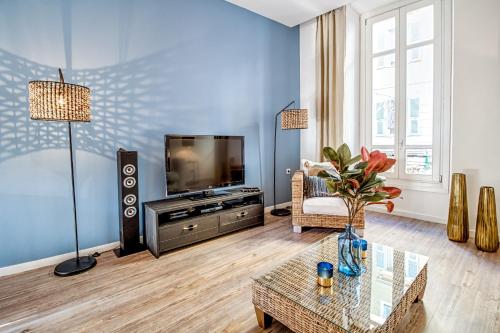 un salon avec une télévision et une table dans l'établissement Nestor&Jeeves - ADRIANA - Central, Close sea, à Nice