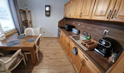 eine Küche mit einer Holztheke und einem Tisch in der Unterkunft Апартамент Барок 2 in Lowetsch
