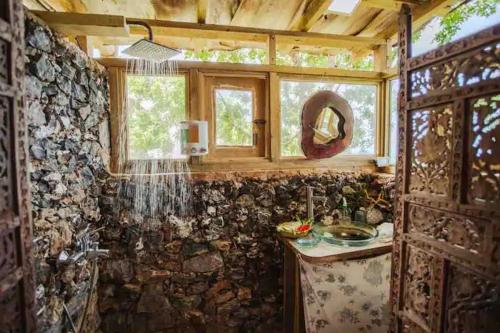 baño con lavabo y pared de piedra en Casa El Paraíso, Las Galeras en Las Galeras