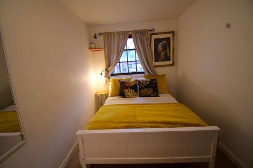 sypialnia z łóżkiem z żółtą pościelą i oknem w obiekcie Stunning 2 bed apartment, in the heart of Exeter! w mieście Exeter