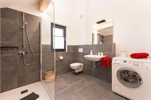 un bagno con lavatrice e lavandino di CozyNook Leuterschach a Marktoberdorf