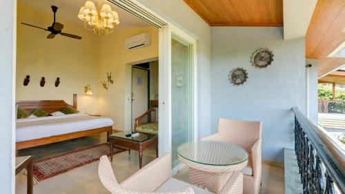 a bedroom with a bed and a table and chairs at Ramsukh Resorts and Spa in Mahabaleshwar