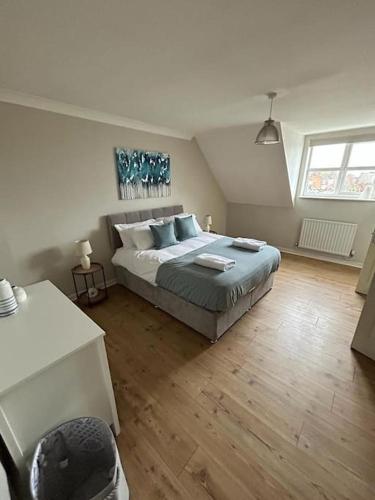 1 dormitorio con 1 cama grande con almohadas azules en Modern & Comfortable with Free Parking, en Bedford