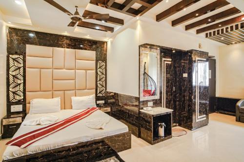1 dormitorio con 1 cama grande y espejo en Bombay Beach Resort, en Mandarmani