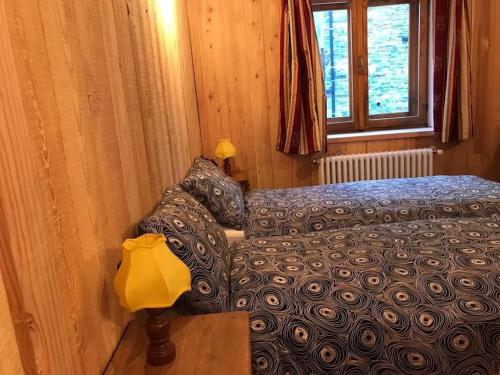 a bedroom with a bed and a couch next to a window at Alloggio Kenne, a 200m dagli impianti Monterosaski in Champoluc
