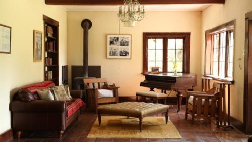uma sala de estar com um sofá e um piano em Casa Origen em Pirque