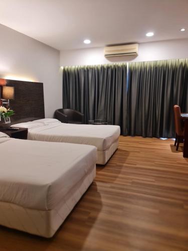 a hotel room with two beds and a desk at BV3 Studio Type with swimming pool in KK City Centre in Kota Kinabalu