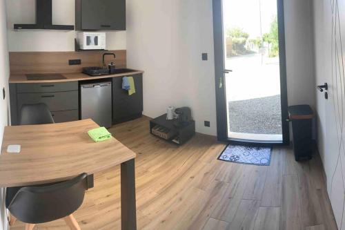 a kitchen with a wooden table and a kitchen with a door at T1 ( Saint-Jean-de-Monts ) calme et central in Saint-Jean-de-Monts