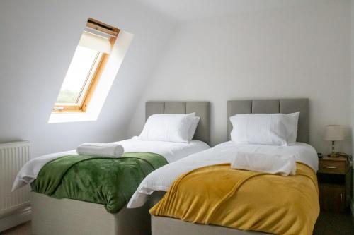 Duas camas sentadas uma ao lado da outra num quarto em River View House em Lincoln