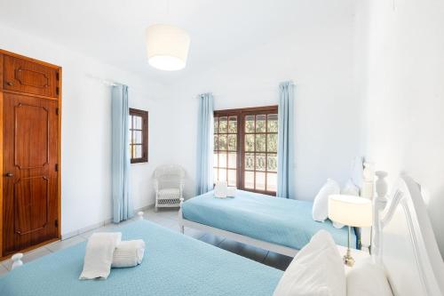 um quarto branco com 2 camas e uma janela em Villa Guerreiro em Albufeira