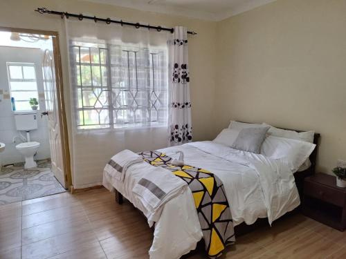 1 Schlafzimmer mit einem Bett und einem Bad in der Unterkunft Ol-tome Country House - Nakuru in Nakuru