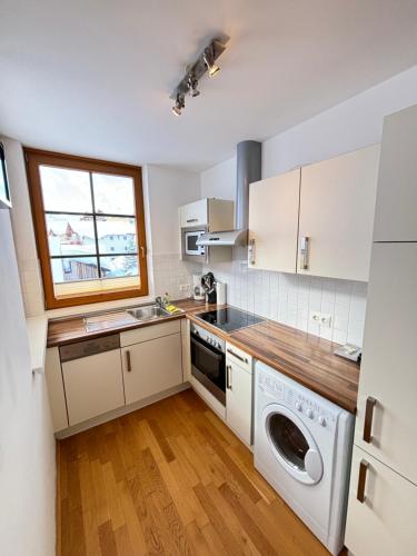 a kitchen with white cabinets and a washer and dryer at Steinadler Schaidberg FL - Skiing Holiday in Obertauern in Obertauern