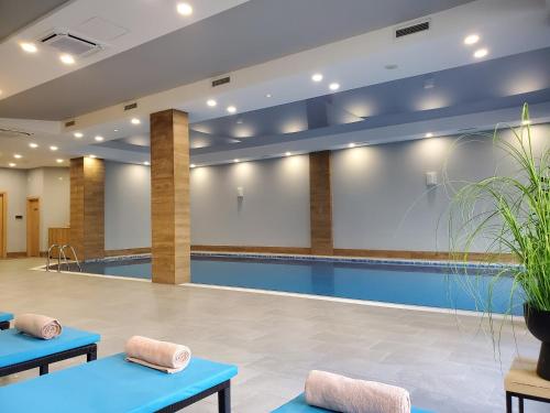 a pool in a hospital lobby with blue tables at Hotel Salvador in Batumi