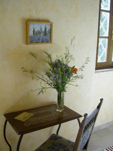 a vase of flowers sitting on a table with two chairs at Fattoria Poggerino in Radda in Chianti
