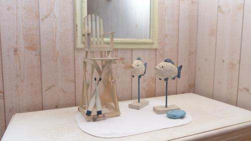 une étagère avec deux oiseaux et une chaise dans l'établissement Cottage maritime avec vue exceptionnelle sur mer, à Baden