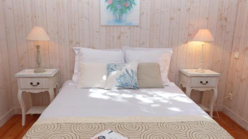um quarto com uma cama com 2 candeeiros e 2 mesas em Cottage maritime avec vue exceptionnelle sur mer em Baden