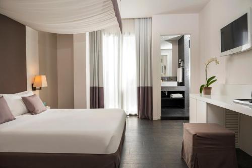 una camera con un grande letto bianco e un soggiorno di Hotel Ines a Cattolica