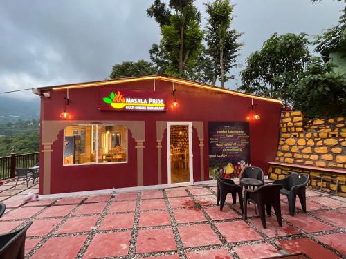a red building with chairs and tables in front of it at NIVEDAN HOTEL AND RESORT in Nainital