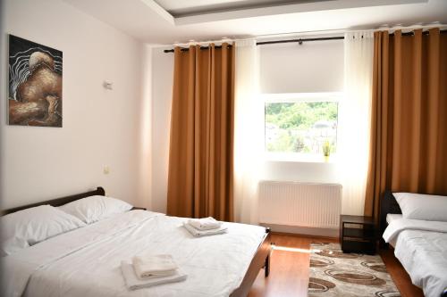 a hotel room with a bed and a window at Apartmani swiss Gold in Priboj