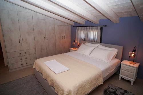 a bedroom with a large bed and a blue wall at Villa Stratos Corfu -private pool and hot tub in Corfu
