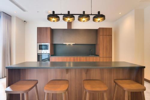 a kitchen with a bar with stools and a counter top at Livensa Living Studios Bilbao in Bilbao