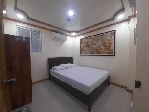 LUMBAYAN BEACH RESORT في Dawis: غرفة نوم صغيرة بها سرير وباب