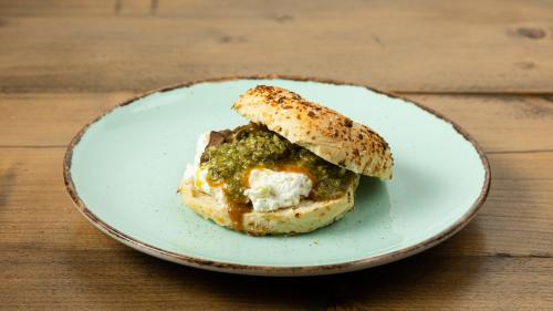 a sandwich on a plate on a wooden table at Cohort Koukaki in Athens