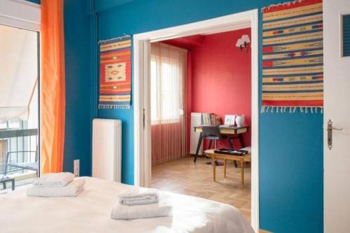 um quarto com paredes azuis e vermelhas e uma cama em Casa de Colores, next to the metro em Atenas