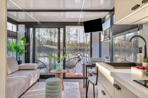 a kitchen and living room with a view of the water at Charming Tiny Houseboat Escape Near Amsterdam by Weltevreden Experience in Kortenhoef