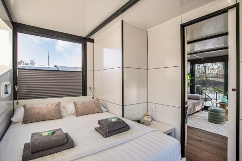 ein Schlafzimmer mit einem großen Bett und einem großen Fenster in der Unterkunft Charming Tiny Houseboat Escape Near Amsterdam in Kortenhoef