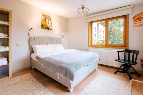 1 dormitorio con 1 cama, 1 silla y 1 ventana en House with Garden and Bosphorus View in Kuzguncuk, en Estambul