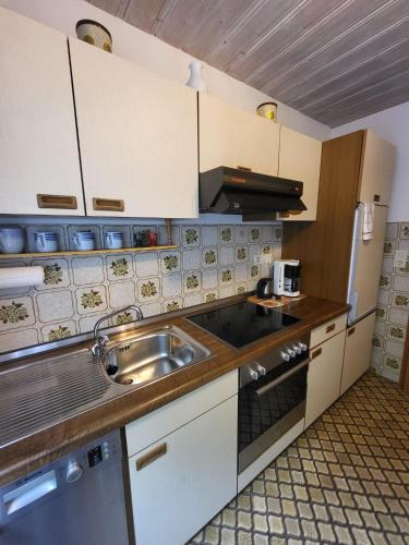 a small kitchen with a sink and a stove at Landhaus Weiß in Bad Reichenhall