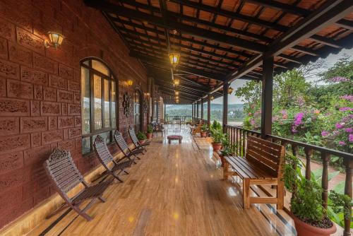 a porch with benches and flowers on a building at SaffronStays Athaang, Dapoli in Ānjarle