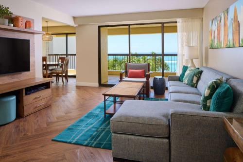 a living room with a couch and a television at Aston Waikiki Beach Tower in Honolulu