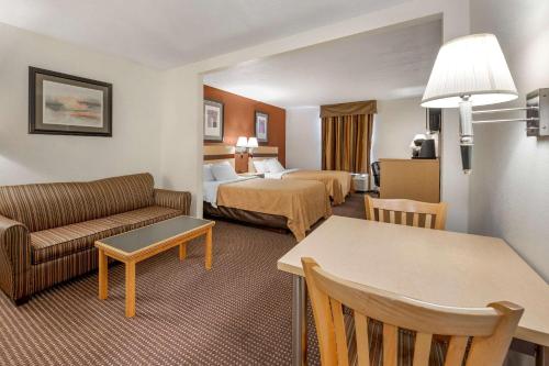 ObetzにあるQuality Inn & Suites Southのベッド2台とソファが備わるホテルルームです。