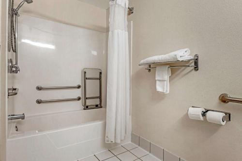 a bathroom with a tub and a shower with towels at Quality Inn & Suites South in Obetz