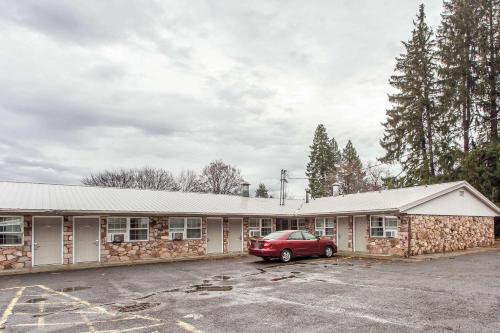 a building with a car parked in a parking lot at Rodeway Inn La Grande - Island City in La Grande