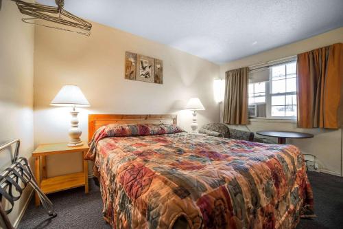 a hotel room with a bed and a window at Rodeway Inn La Grande - Island City in La Grande