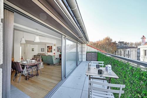 un patio avec une table et des chaises sur un balcon dans l'établissement Le loft des Papes - 2 terrasses - Vue Panoramique sur la ville - AC CLIM, à Avignon
