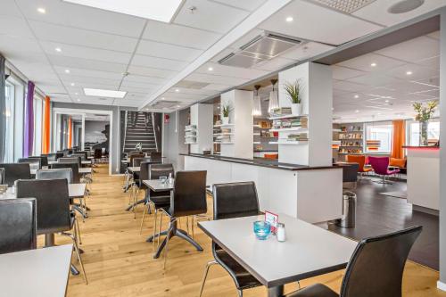um escritório com mesas e cadeiras numa cafetaria em Sure Hotel by Best Western Stockholm Alvsjo em Estocolmo