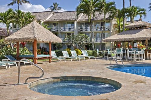a resort with a swimming pool and chairs and a building at Aston Islander On The Beach in Kapaa