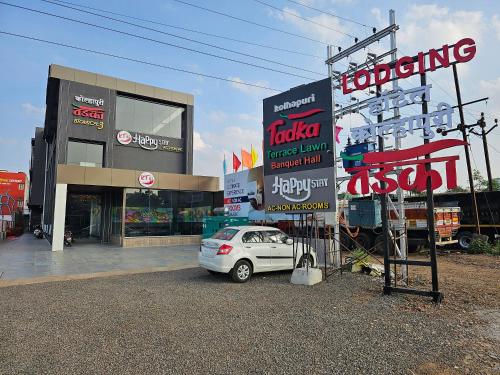 a white car parked in front of a store at Hotel Happy Stay Kolhapur 2 km from kolhapur airport in Kolhapur