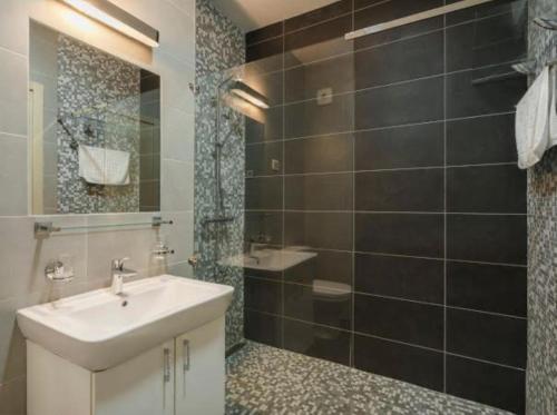 Un baño con lavabo y ducha en Lavender Bay Apartment C21, en Donji Morinj