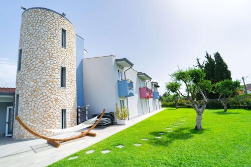 un edificio con una hamaca junto a un patio en Best Western Plus Sabaudia Hotel en Sabaudia