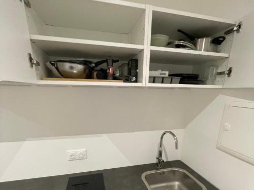 eine Küche mit weißen Schränken und einem Waschbecken in der Unterkunft Studio meublé Longwy-Haut Centre in Longwy